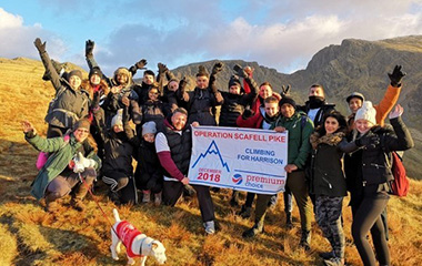Premium Choice staff holding a banner at the top of Scafell Pike